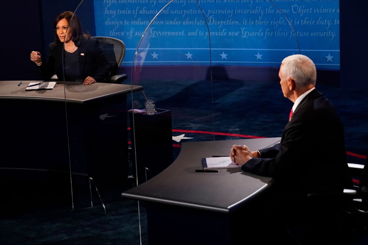 Vice President Mike Pence listens to Kamala Harris during their debate