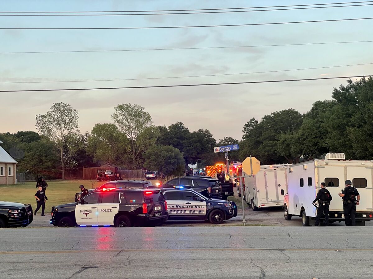 Law enforcement work the scene where multiple shots were fired near the area of Cedarcrest Drive and Diamond Oaks Drive in Haltom City, Texas, Saturday, July 2, 2022. (James Hartley/Star-Telegram via AP)