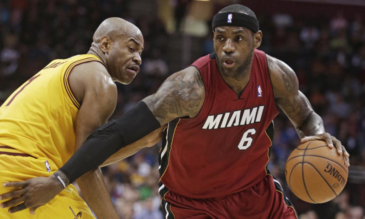 Miami Heat forward LeBron James, right, drives around Cleveland Cavaliers guard Jarrett Jack during the second quarter of the Heat's 100-96 victory on Tuesday.