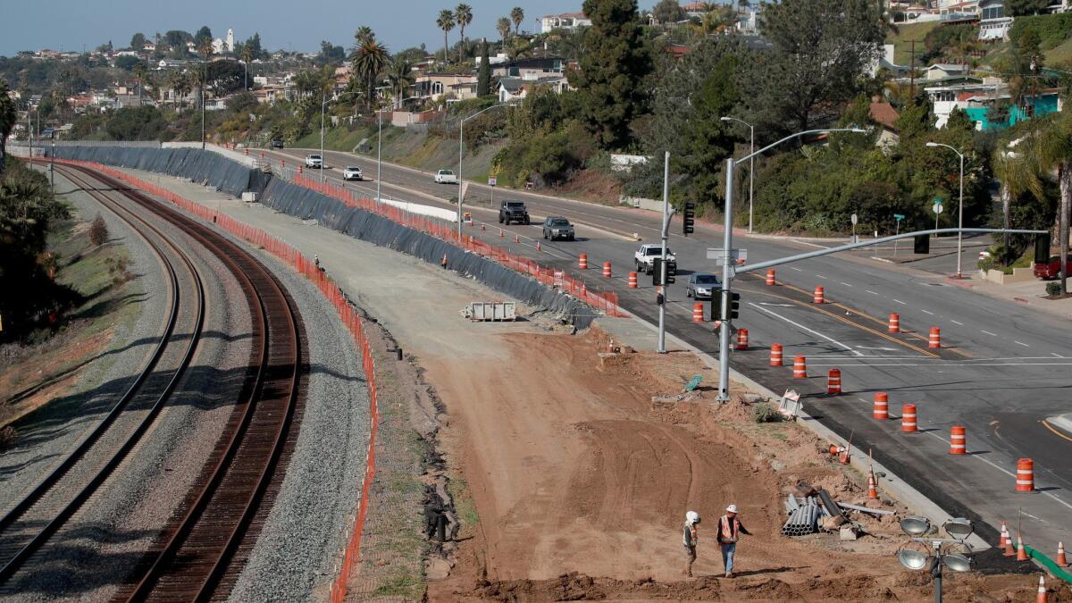 A crew works in January on San Diego's Mid-Coast Corridor Transit Project. City proposals could dramatically increase housing near transit.