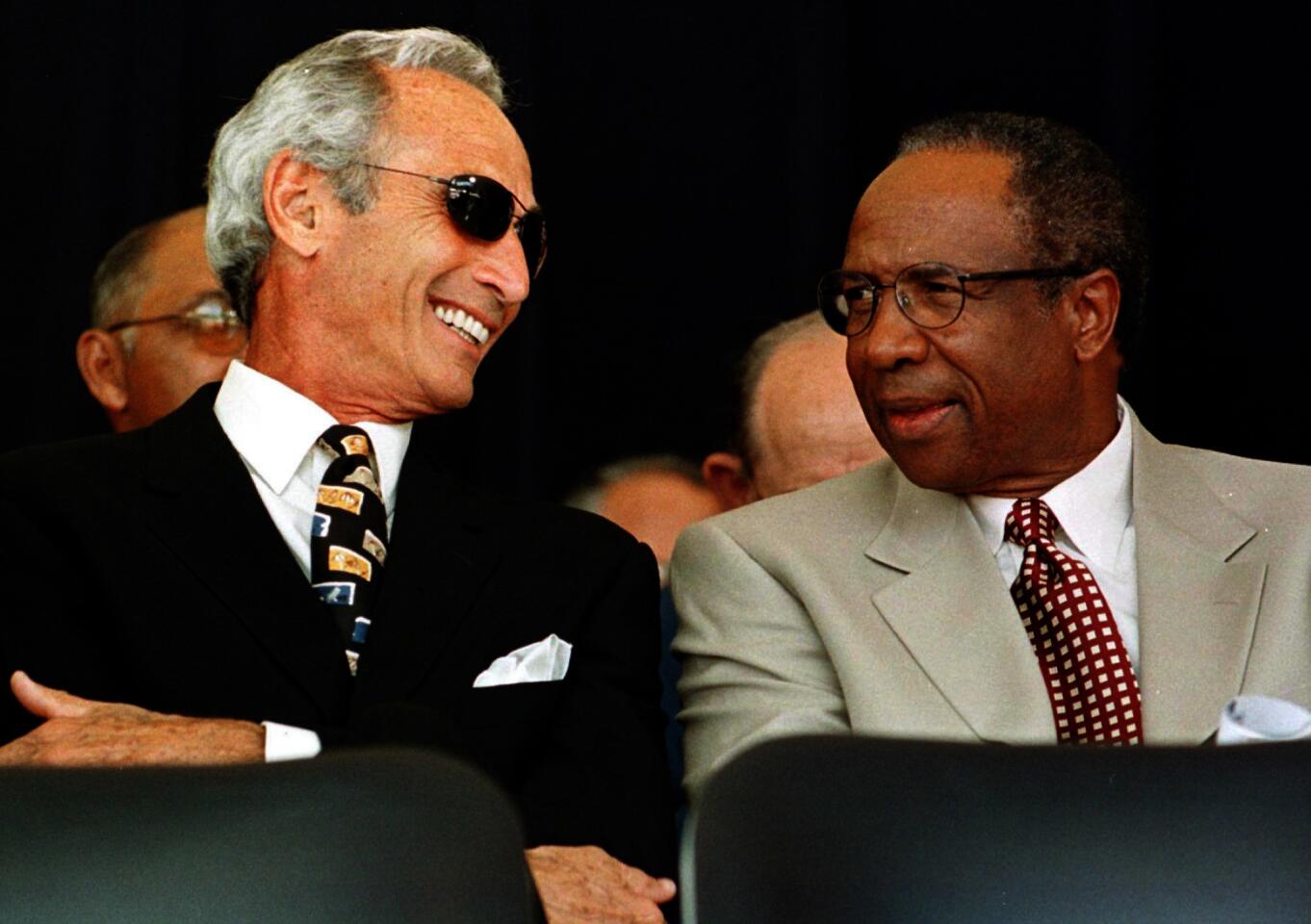 Sandy Koufax, left, a Hall of Fame Dodgers pitcher, talks with fellow Hall of Famer Frank Robinson after they took the stage before induction ceremonies in Cooperstown, N.Y., July 26, 1998.
