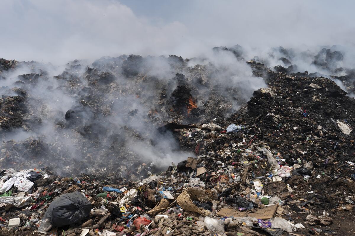 Montaas de basura se queman en un vertedero en Villa Nueva, Guatemala