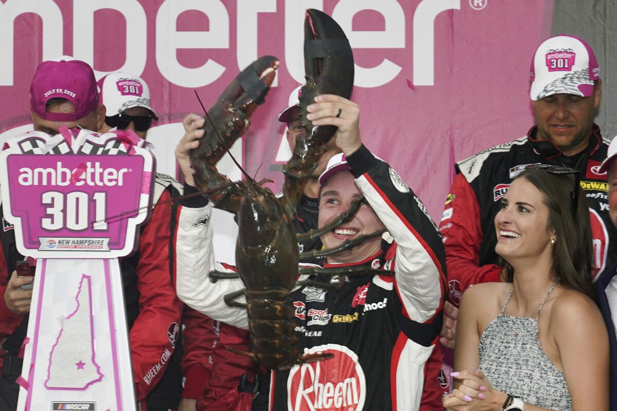 Christopher Bell holds up a giant lobster while celebrating with his wife, Morgan.