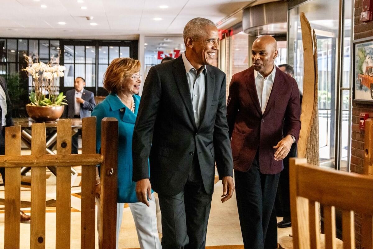 In this photo provided by Dylan Goodman, former President Barack Obama, center, walks with Valerie Jarrett, left, and Harvard basketball coach Tommy Amaker on their way into "The Breakfast Club" in Cambridge, Mass., Friday, Sept. 9, 2022. Obama returned to Cambridge on Friday to attend the club, a group formed by Amaker with law professors Charles Ogletree and Ron Sullivan to create a community of Black leaders and connect it with his team. (Dylan Goodman via AP)