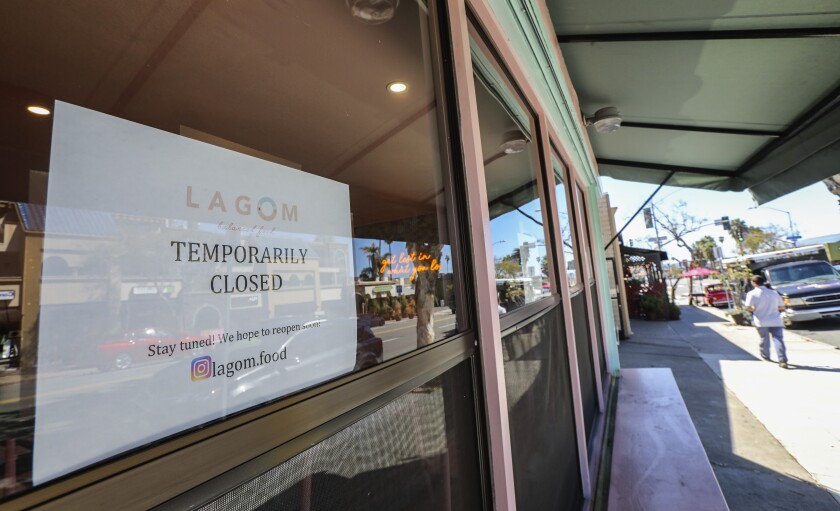 A La Jolla business displays a COVID-19-related sign.