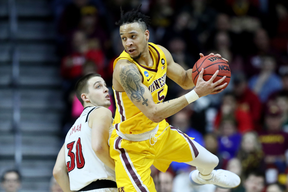 Amir Coffey of the Minnesota Golden Gophers controls the ball against Louisville.