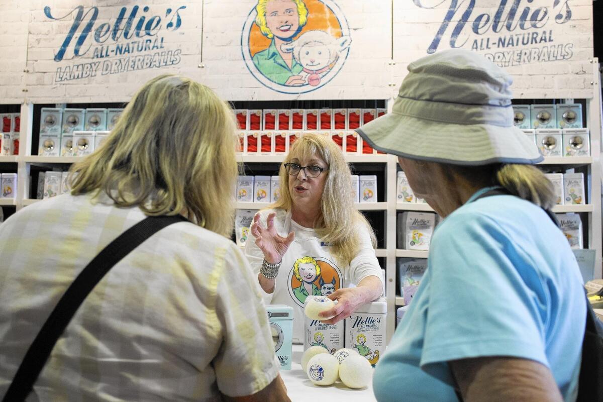 Donna Knight, center, talks about Nellie’s All-Natural Lamby Dryerballs, made from 100% felted New Zealand wool, at the Orange County Fair on Wednesday. Nellie’s All-Natural, based in Canada, is a new vendor at the fair this year.