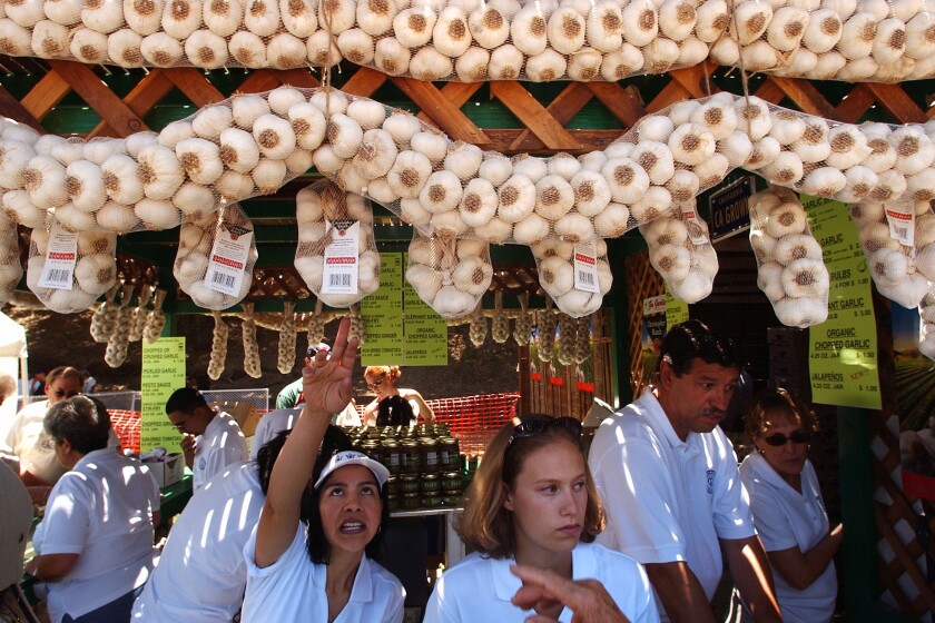 Esperanza Pineda, center left, and Jennifer Smith, center right, sell locally-grown garlic at the Gilroy Garlic Festival in Gilroy, Calif., on Saturday, July 24, 2004. Over 100,000 visitors are expected to attend the weekend-long celebration in Gilroy. (AP Photo/Marcio Jose Sanchez)