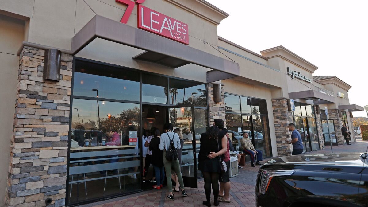 A couple waits in line outside 7 Leaves Cafe in Garden Grove. The cafe is part of a wave of newer restaurants in Little Saigon.