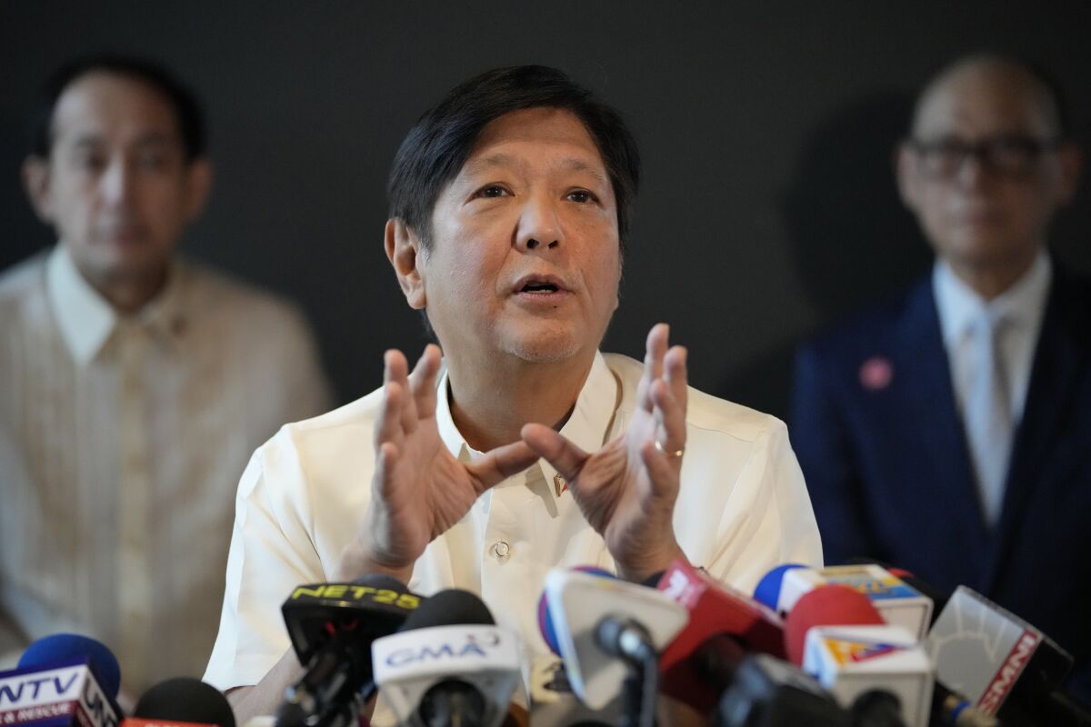 Philippine President-elect Ferdinand "Bongbong" Marcos Jr., center, gestures during a press conference at his headquarters in Mandaluyong, Philippines on Monday, June 20, 2022. Marcos expressed fears Monday of a potential food crisis largely due to the war in Ukraine and said he would also serve as agriculture chief when he takes office to brace for possible emergencies. (AP Photo/Aaron Favila)