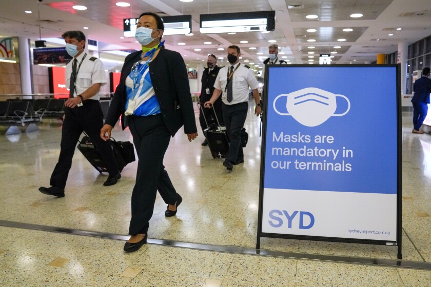 A flight crew walk through the terminal at Sydney Airport, Monday, Nov. 29, 2021.  
