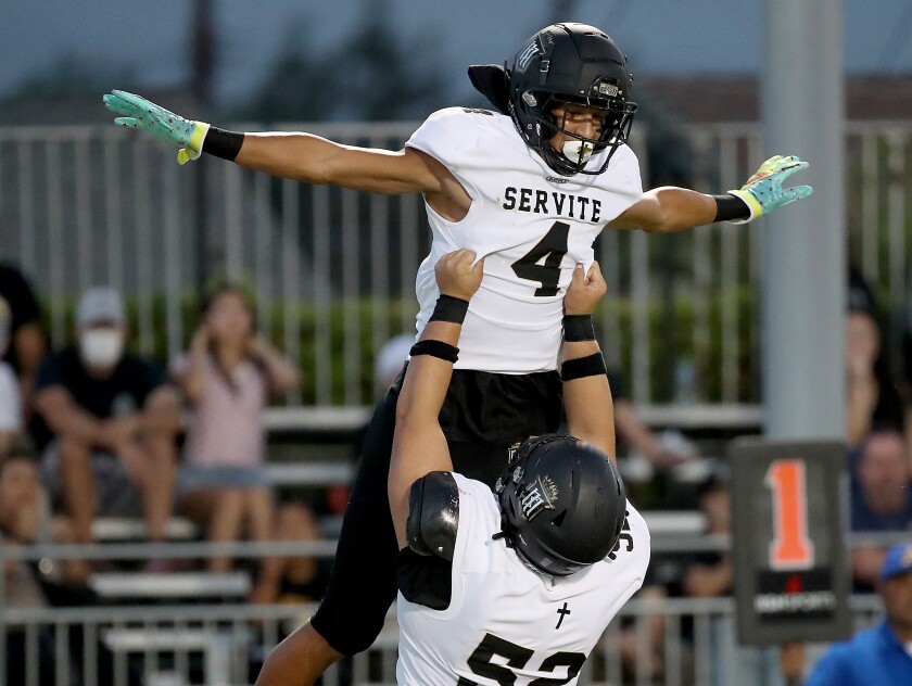 Servite receiver Tetairoa McMillan, left, celebrates with teammate Josiah Laban.