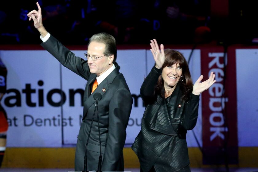 ANAHEIM, CA - JANUARY 11: Ducks owner Henry Samueli and wife Susan wave to the crows as they speak during ceremonies retiring the number of Teemu Selanne of the Anaheim Ducks before the game with the Winnipeg Jets at Honda Center on January 11, 2015 in Anaheim, California. (Photo by Stephen Dunn/Getty Images)