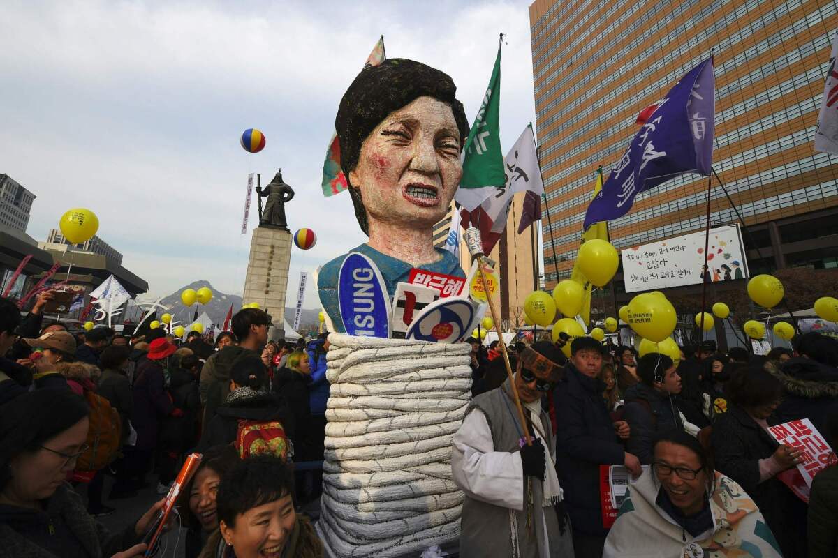 Protesters carry an effigy of South Korean President Park Geun-hye during a demonstration in central Seoul on Saturday.