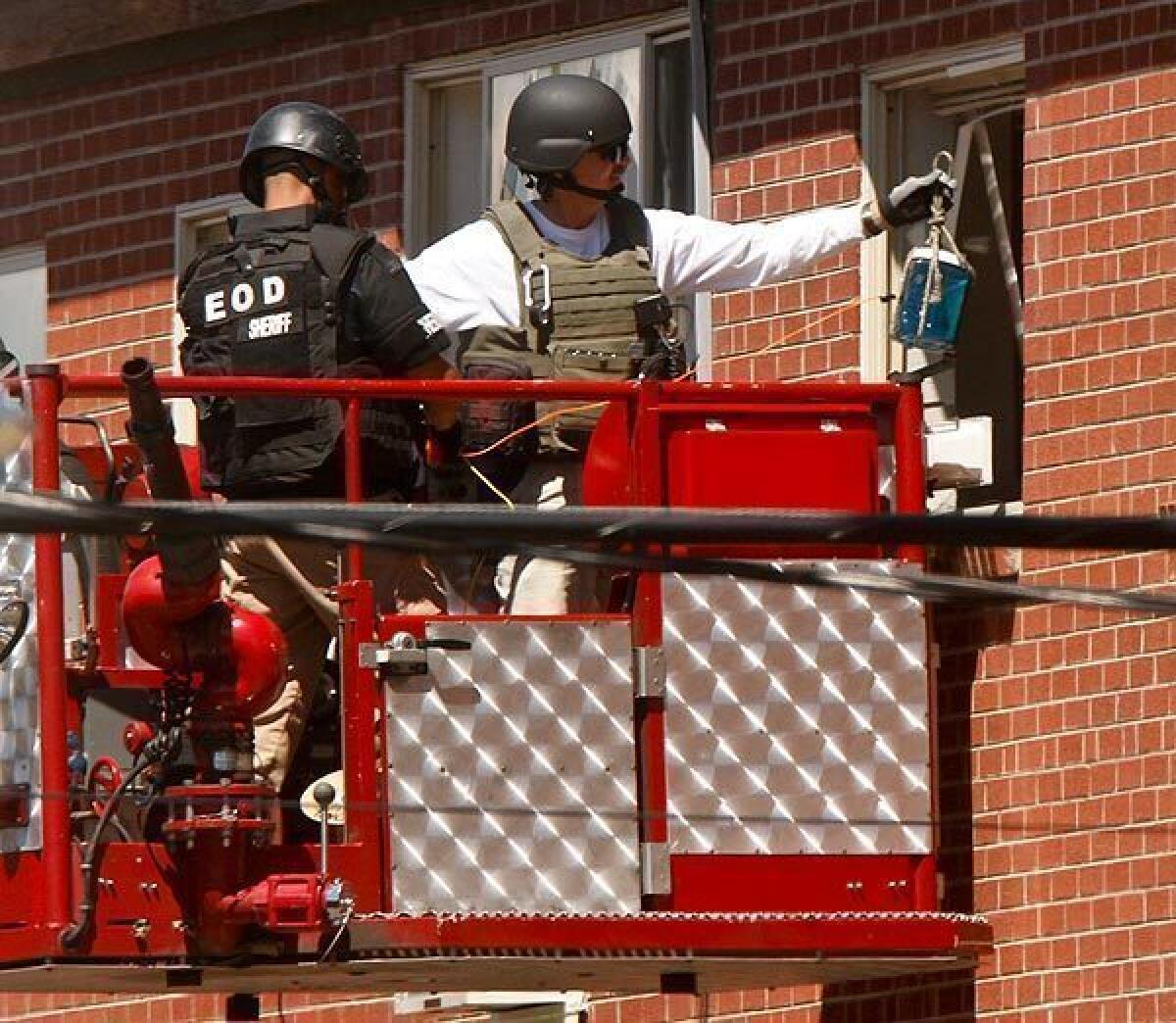 A bomb disposal squad inserts an explosive device into the apartment of mass shooting suspect James Holmes in Aurora, Colo., to destroy some of the booby traps and trip wires left behind.