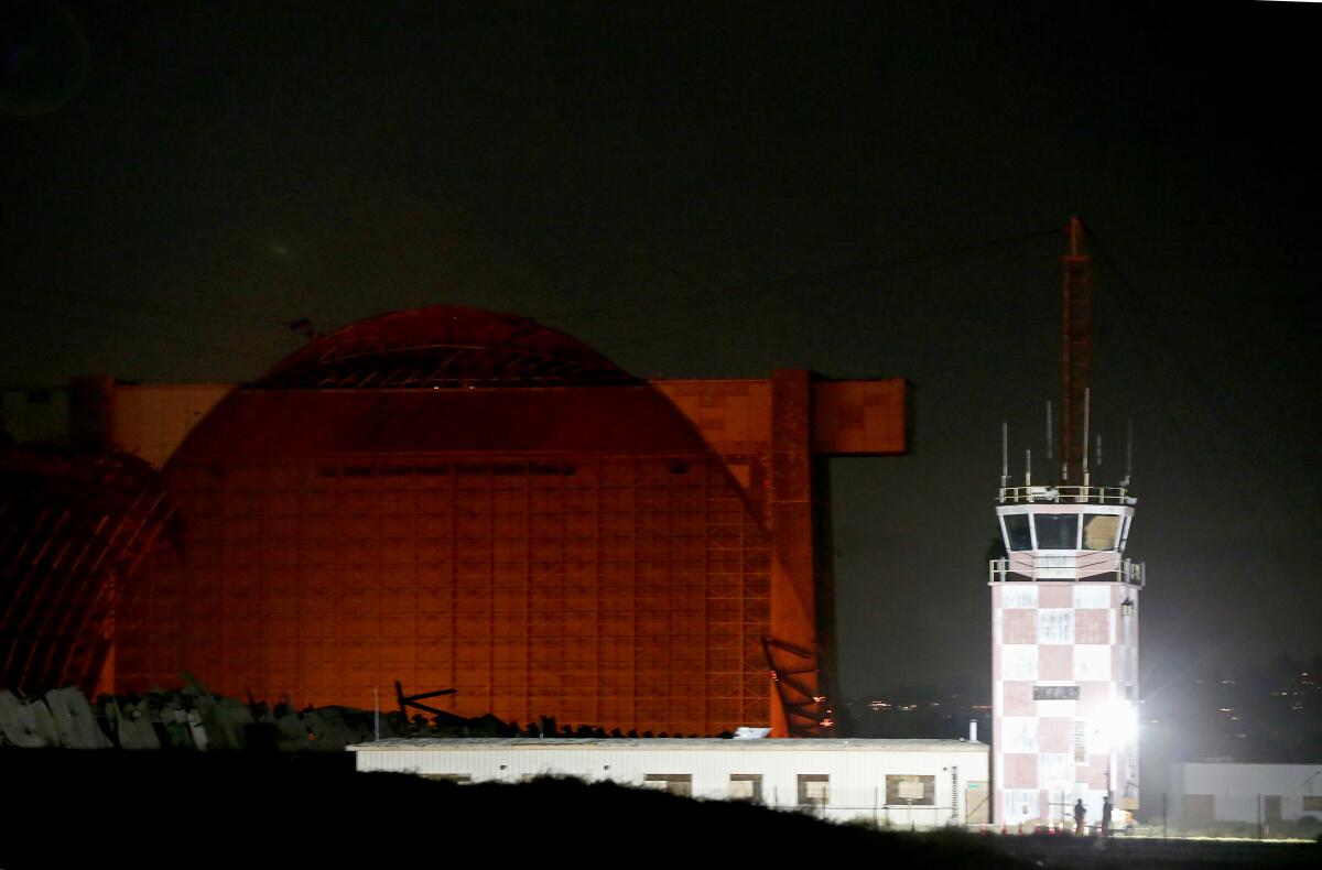 Embers cast a glow on the remains of a historic blimp hangar in Tustin, which caught fire on Nov. 7