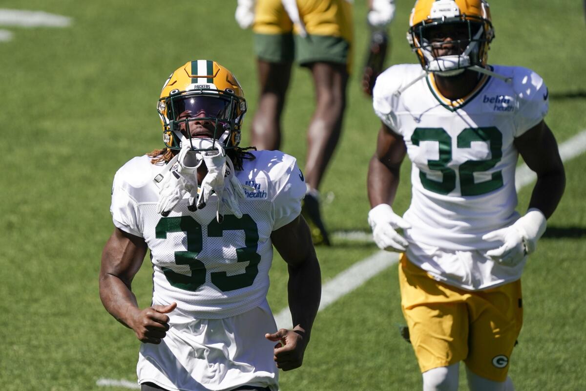 Green Bay Packers running backs Aaron Jones, left, and Tyler Ervin jog during practice in August.