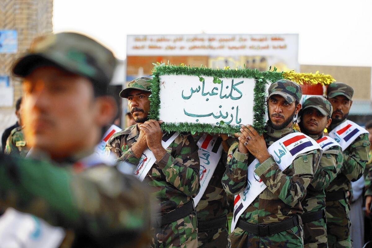 Iraqi mourners in Najaf carry the coffin of a member of the Shiite Muslim militia Asaib Ahl al Haq who was reportedly killed in neighboring Syria in June.