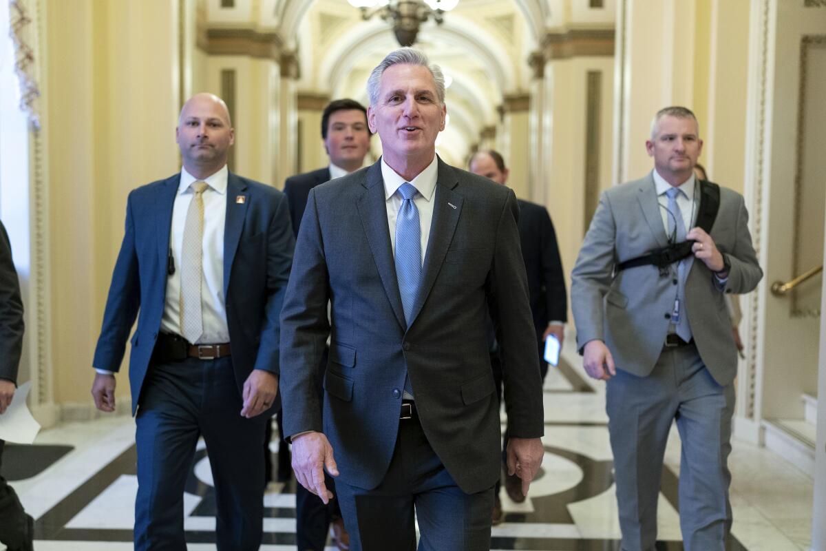House Speaker Kevin McCarthy and colleagues walking through a Capitol corridor.