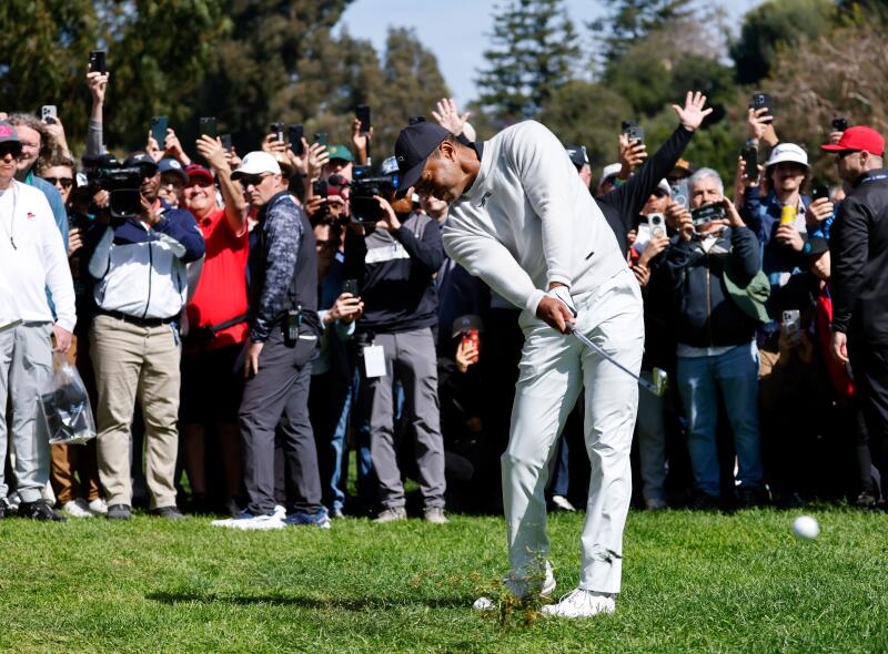 Tiger Woods hits out of the rough on the 12th hole.