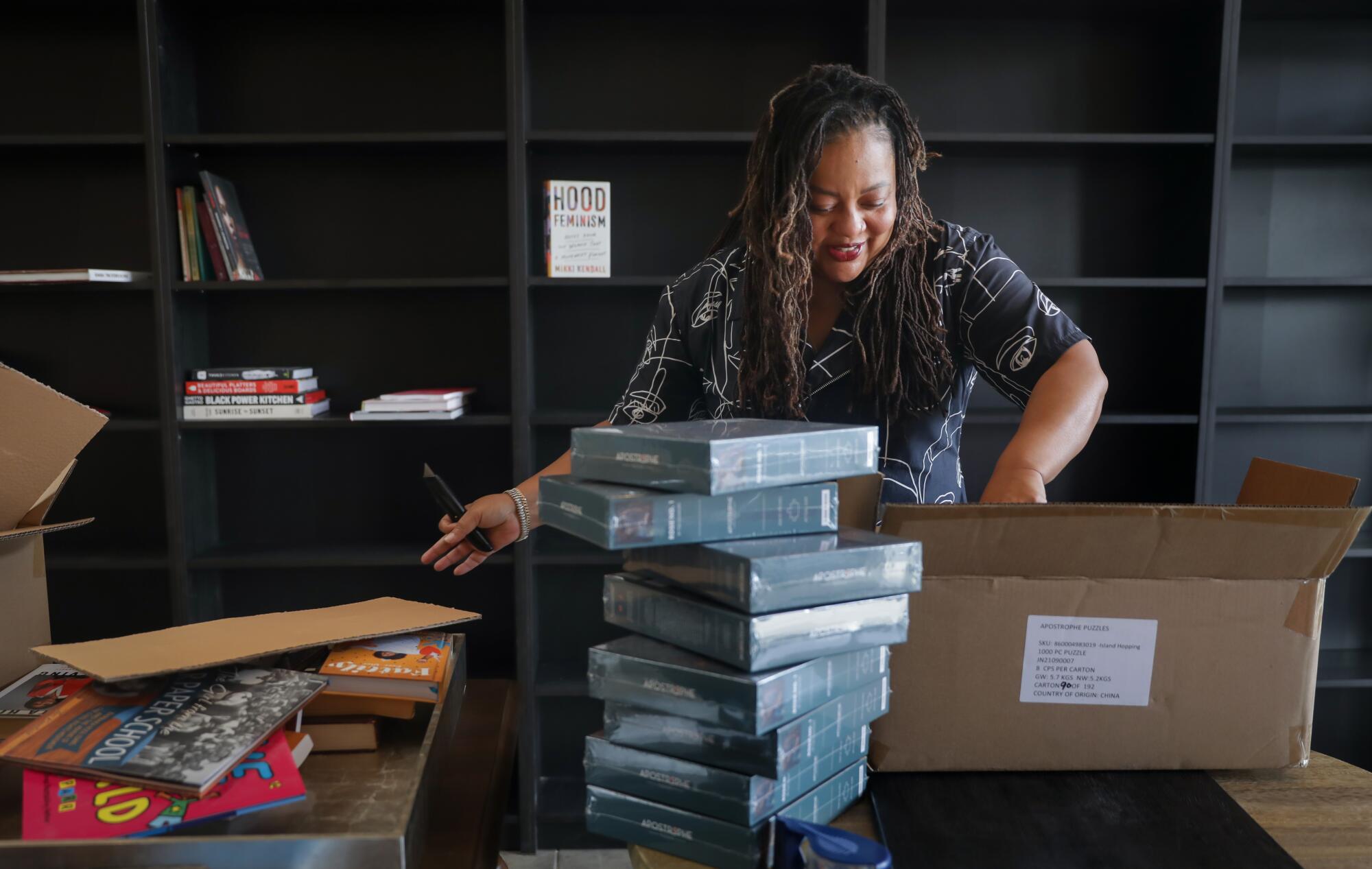 A woman unpacks books from a box 