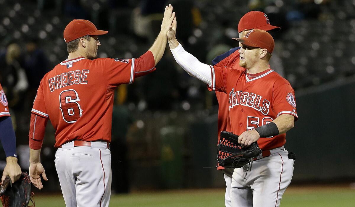 Los Angeles Angels third baseman David Freese (6) and right fielder Kole Calhoun (56) celebrate after the Angels beat the Oakland Athletics, 6-2, on Tuesday.