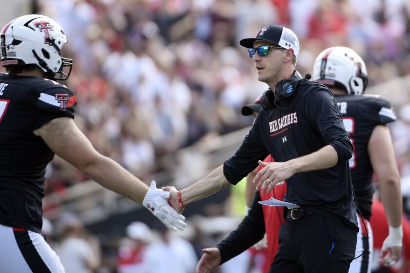 FILE - Texas Tech offensive coordinator Zach Kittley congratulates offensive lineman Ethan Carde after a scoring drive against Houston during the first half of an NCAA college football game on Sept. 10, 2022, in Houston. Kittley is the son of the longtime Texas Tech track coach and NCAA championship winner Wes Kittley. The younger Kittley was always consumed by football growing up. (AP Photo/Justin Rex, File)