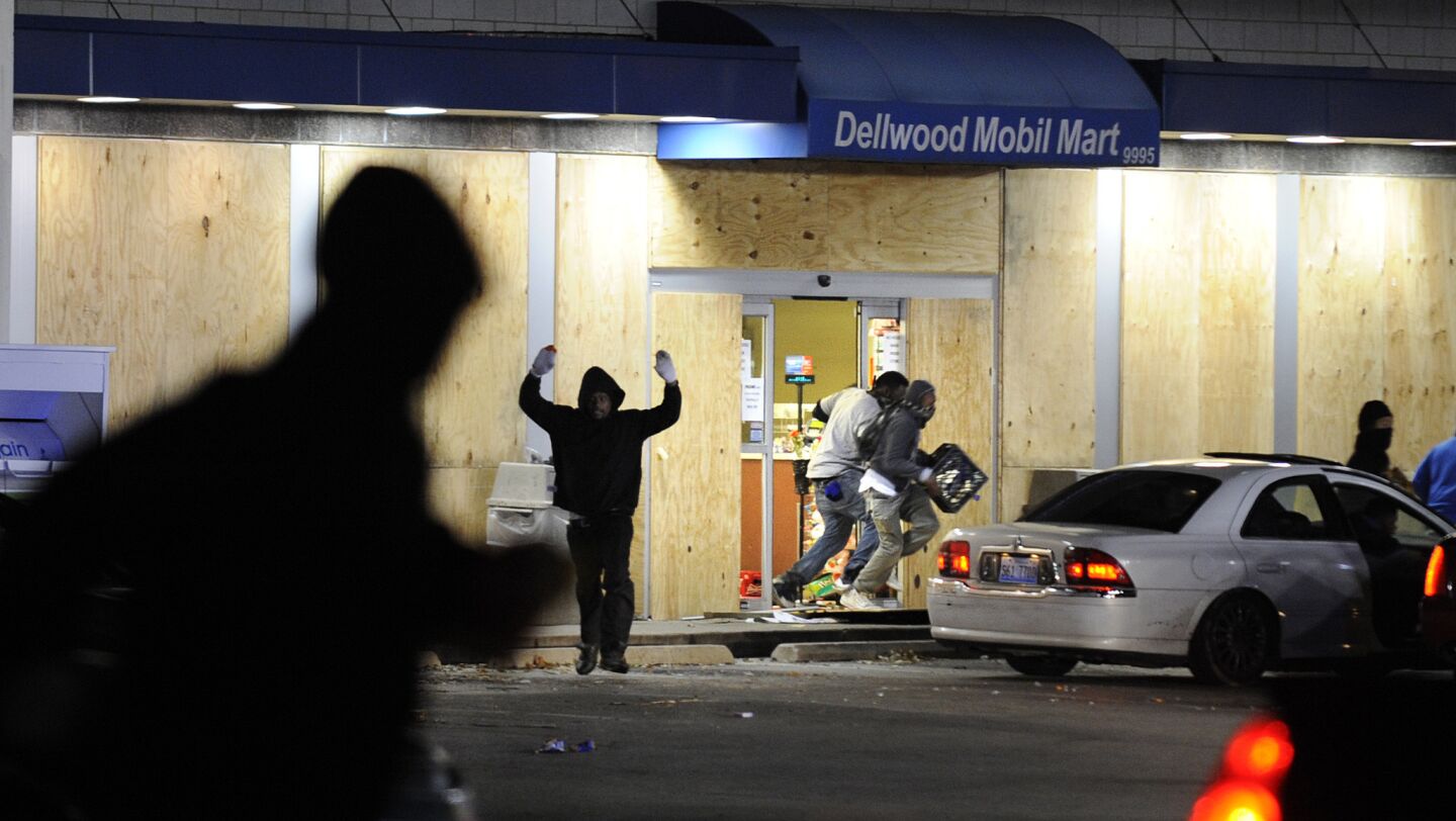 Looters grab merchandise from a Mobil gas station along West Florissant Avenue after a grand jury decision in Ferguson, Mo.
