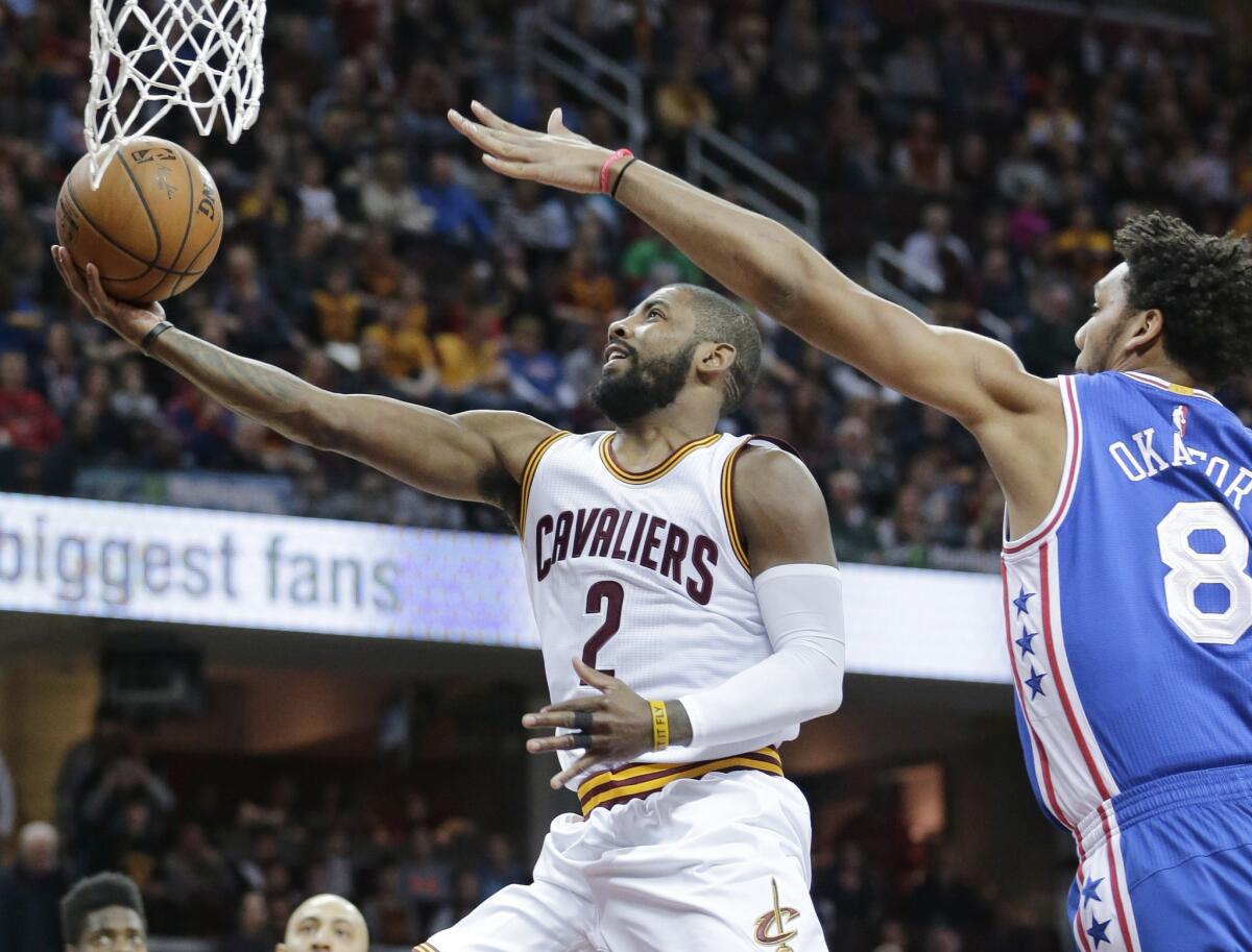 Cavaliers guard Kyrie Irving (2) drives to the basket against 76ers center Jahlil Okafor (8) in the first half.