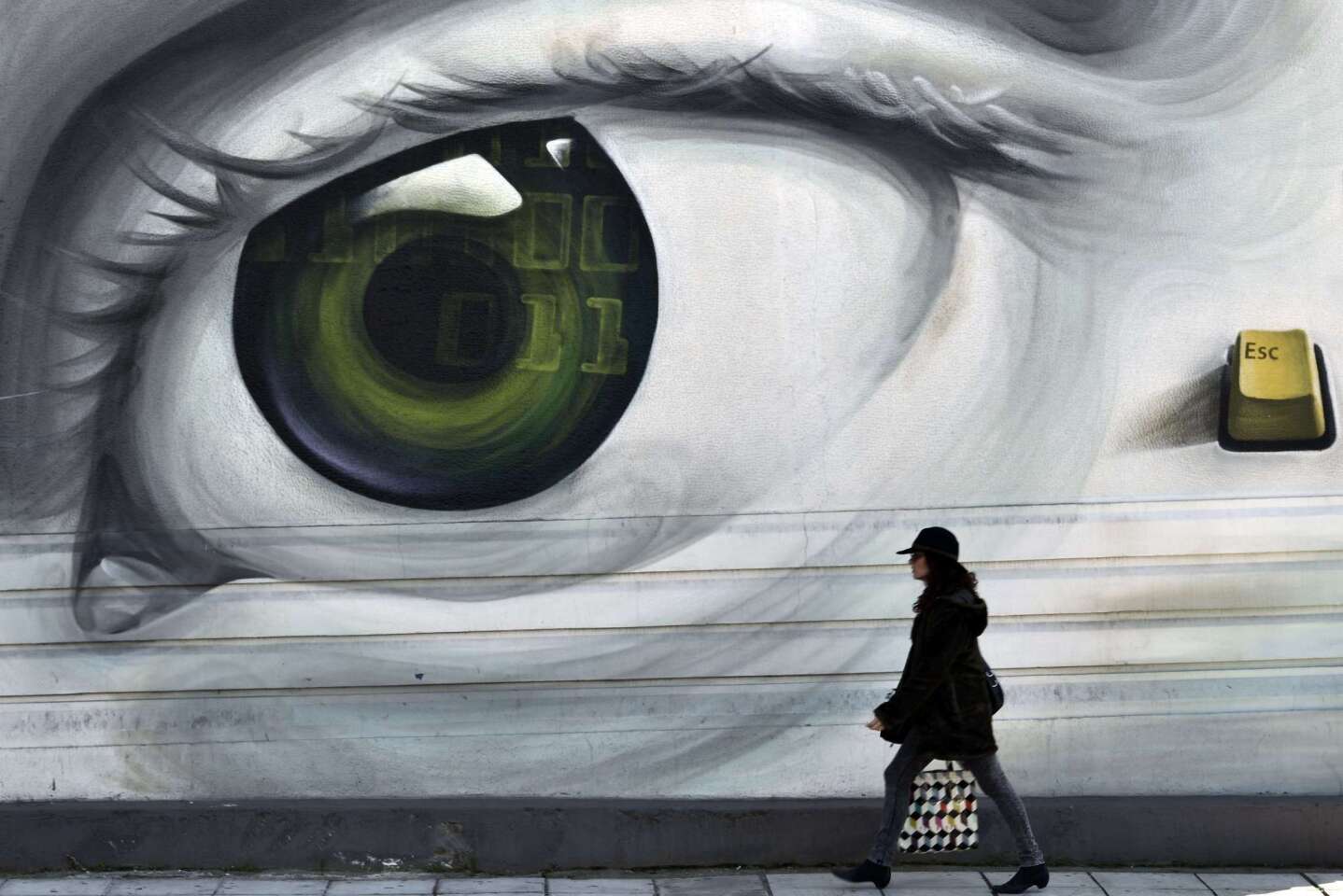 A woman passes by graffiti in central Athens on Feb. 20 as work continues on a bailout compromise in the Greek capital.