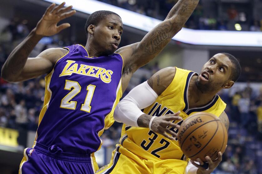 Indiana Pacers guard C.J. Watson, right, puts up a shot in front of Lakers forward Ed Davis during the second half of the Lakers' 110-91 loss Monday.