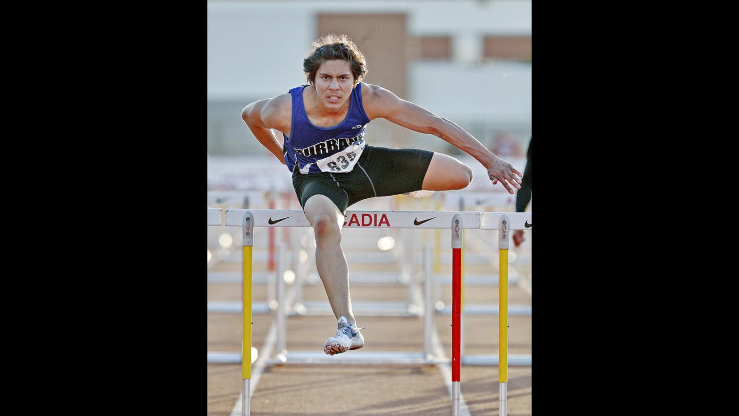 Burbank's Sergio Aguilar clears the final hurdle to win the in the Pacific League track finals at Arcadia High School on Thursday, May 3, 2018.