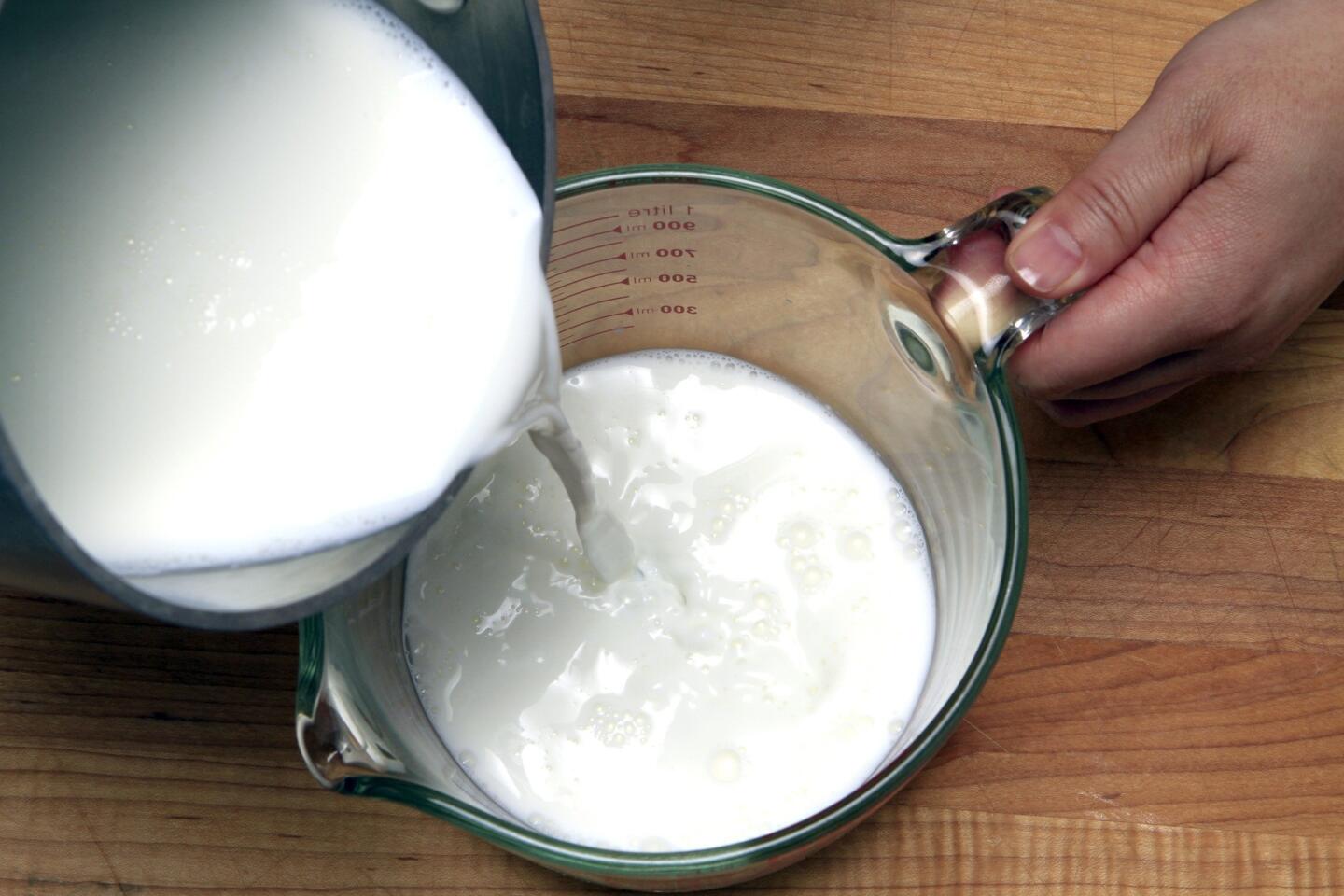 Pouring the milk mixture into a measuring cup.