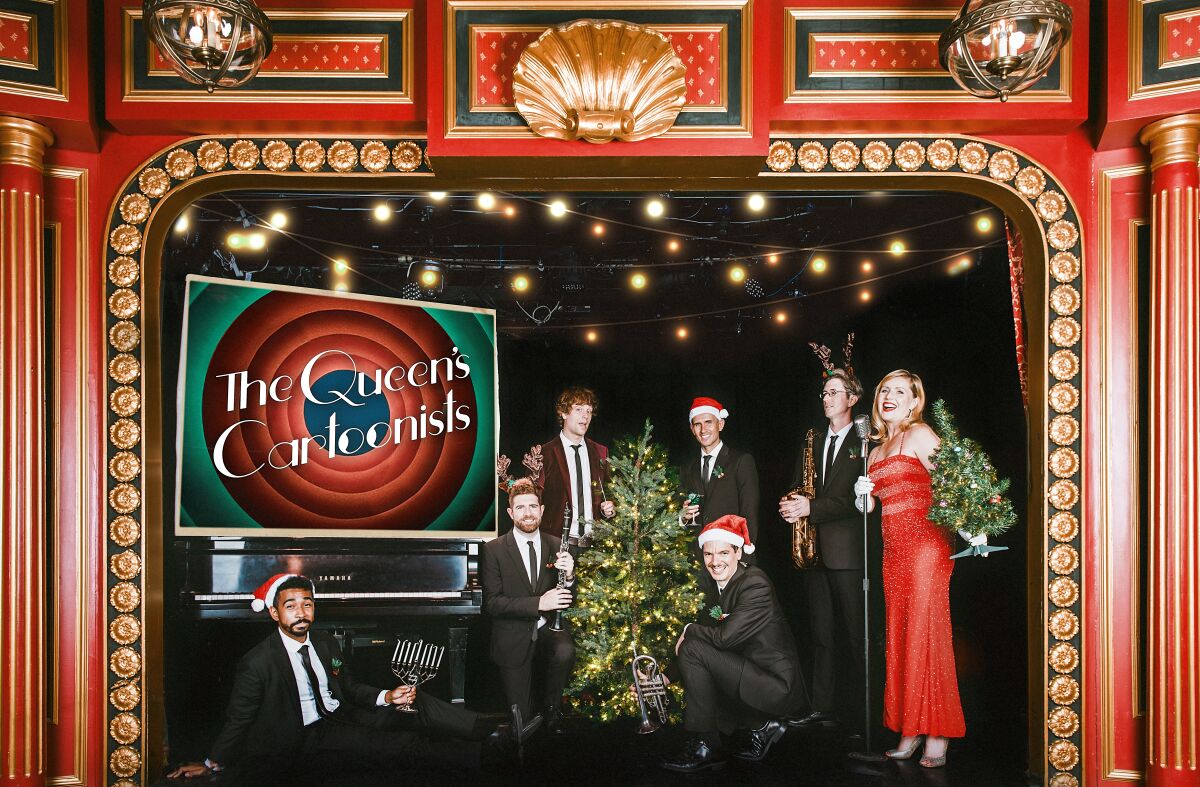 Musicians on an ornate stage, gathered around a small Christmas tree