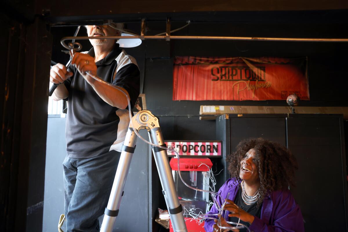 A man on a ladder and a woman looking up at him