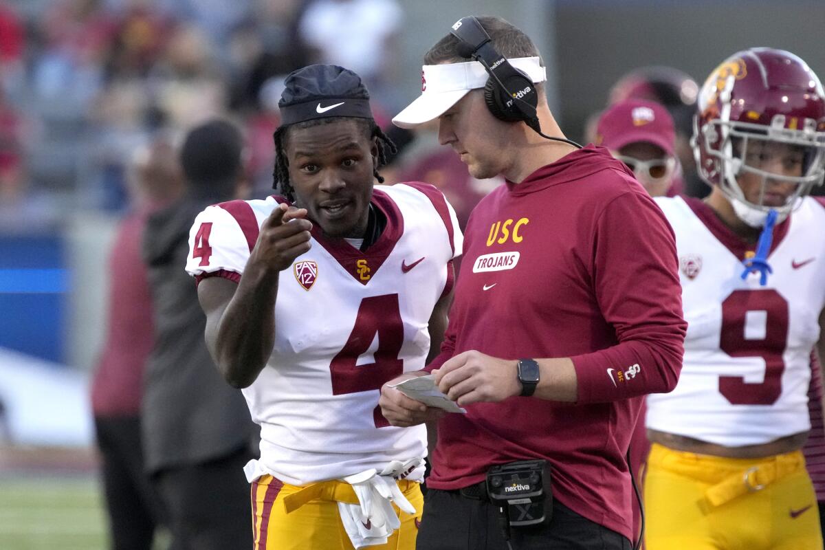 USC defensive back Max Williams talks to Trojans coach Lincoln Riley and points on the sideline during a timeout 