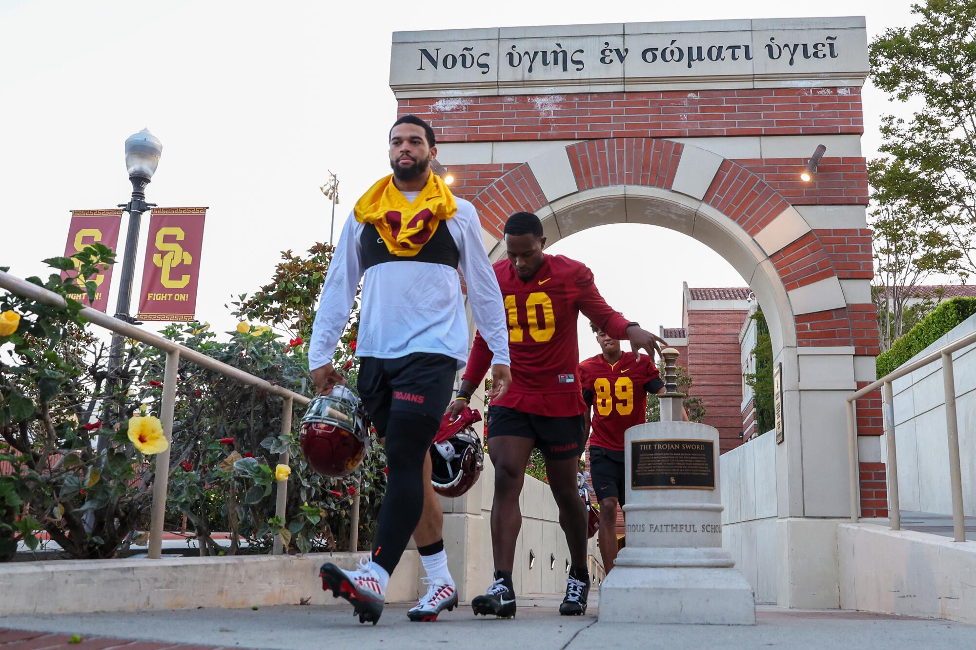 USC quarterback Caleb Williams carries his helmet and walks to Dedeaux Field for preseason practice