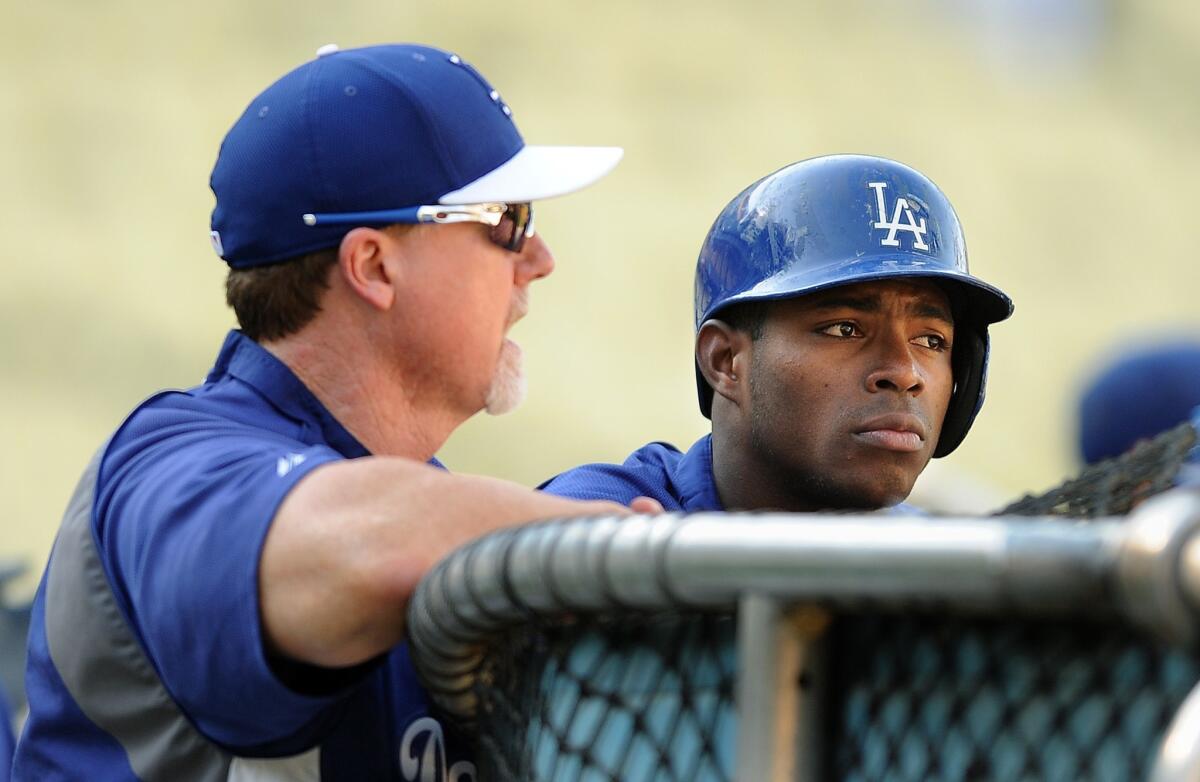 Dodgers hitting coach Mark McGwire, left, speaks with right fielder Yasiel Puig during batting practice before Thursday's game against the San Francisco Giants.