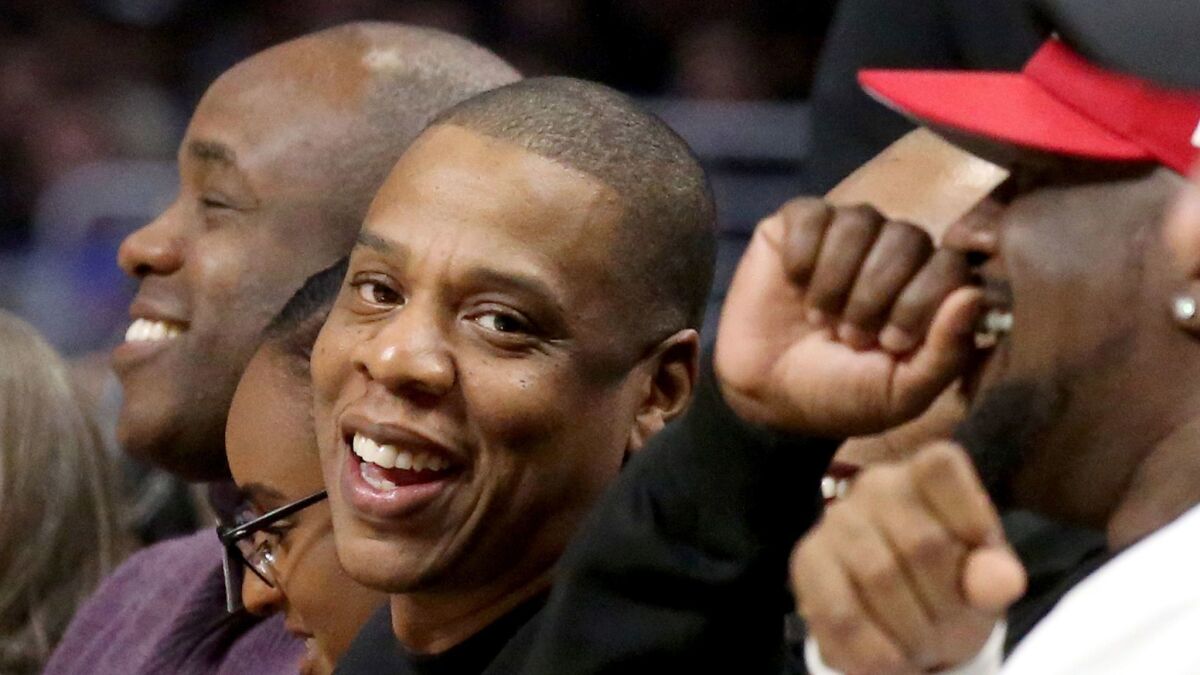Rapper Jay Z, center, at a Clippers-Warriors game in Los Angeles, will continue his long-standing partnership with Live Nation.