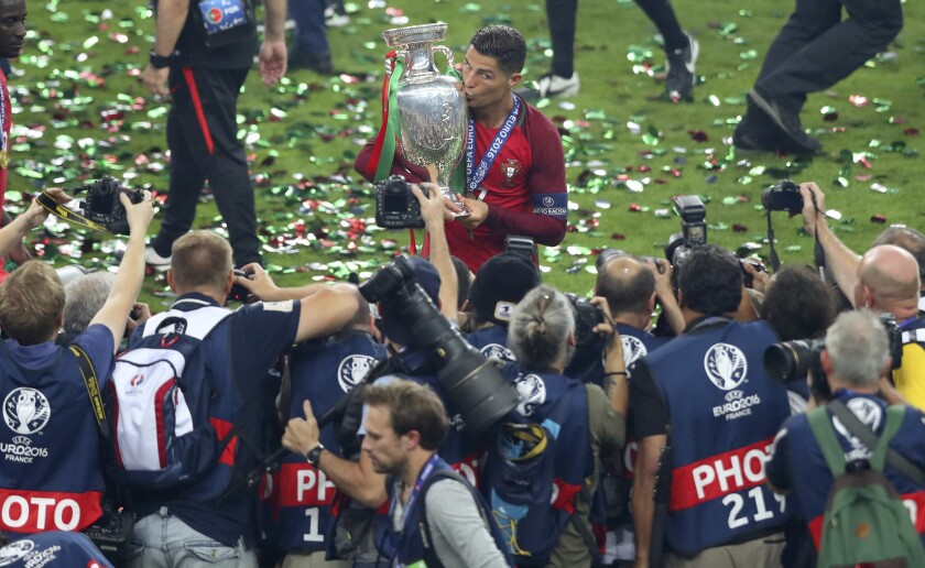 FILE - In this Sunday, July 10, 2016 file photo, Portugal's Cristiano Ronaldo celebrates with the trophy after winning the Euro 2016 final soccer match between Portugal and France at the Stade de France in Saint-Denis, north of Paris. When it comes time for Brazilians to choose who to watch on the soccer field this month — Neymar or Kylian Mbappé, Lionel Messi or Cristiano Ronaldo — the response might be surprising. Because of an unusual set of circumstances, it will be the European Championship that reaches more viewers in Brazil than the Copa America — even though Brazil is expected to host South American the tournament under a completely different set of unusual circumstances. (AP Photo/Thibault Camus, File)