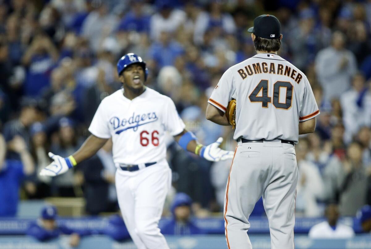 Yasiel Puig, left, exchanges words with San Francisco pitcher Madison Bumgarner, right, after hitting a solo home run Friday during the sixth inning of the Dodgers' 3-1 loss to the Giants.