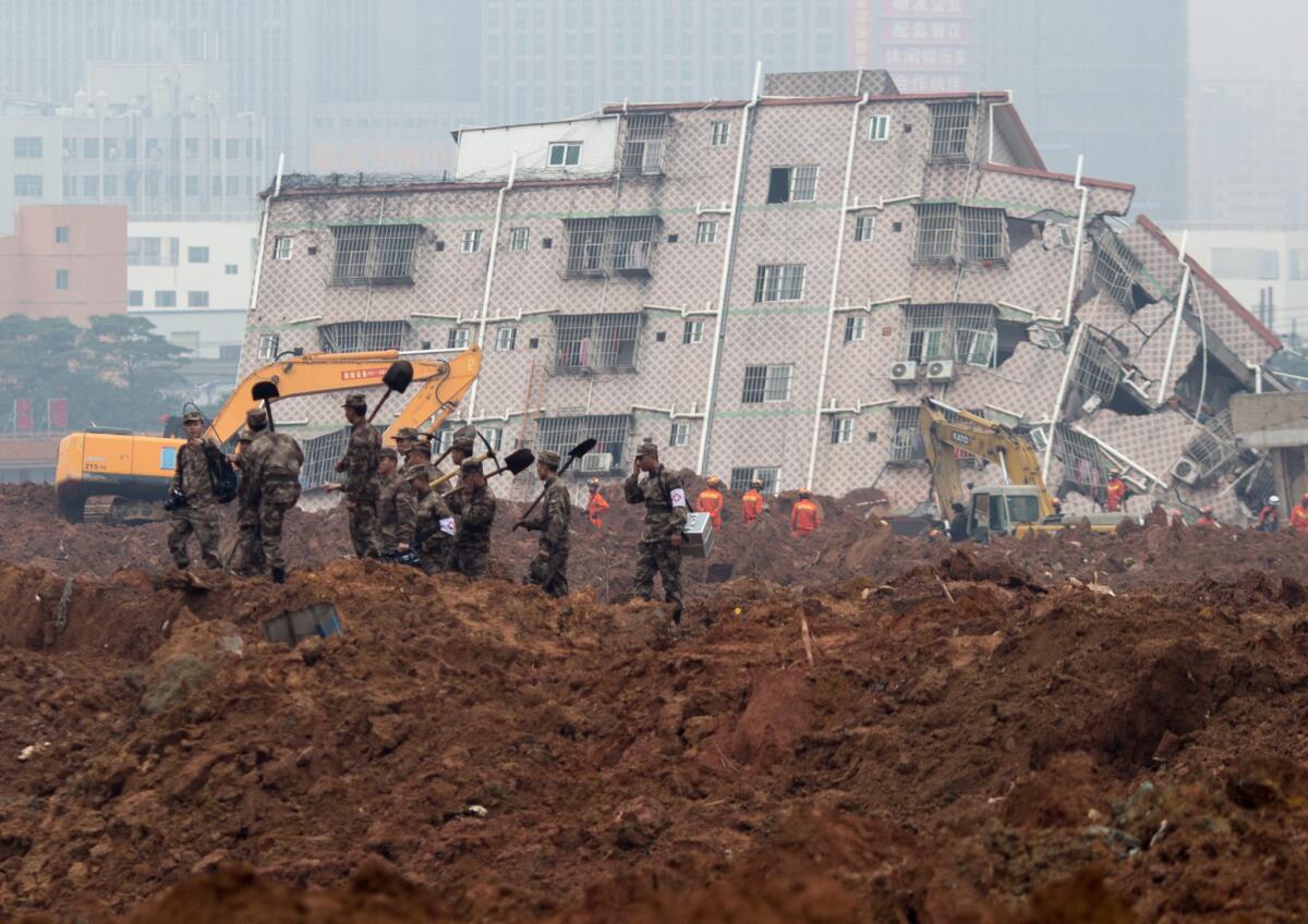 Chinese soldiers arrive with shovels as rescue work continues at factory buildings that were damaged in a landslide in Shenzhen in south China's Guangdong province.