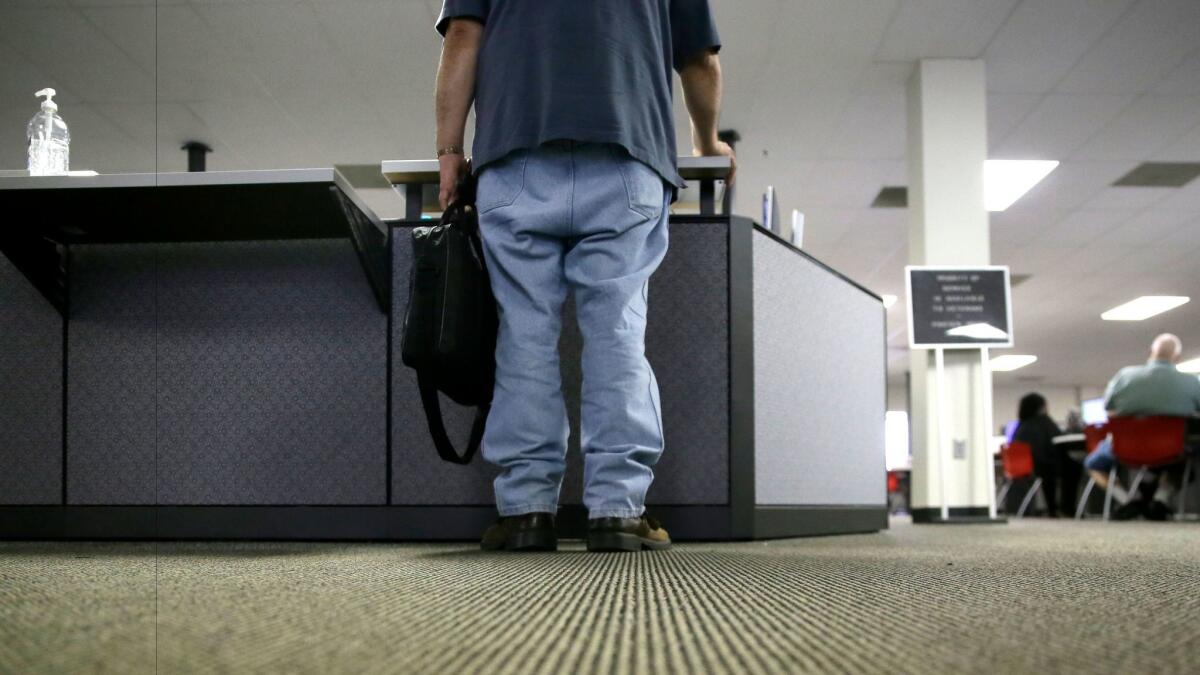 A job seeker checks in at the front desk of the Texas Workforce Solutions office in Dallas on March 10.