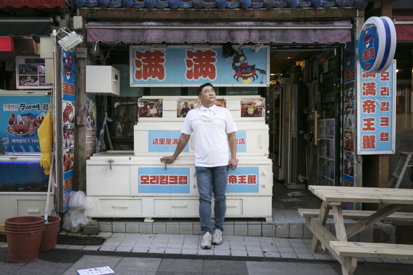 Kim Kyoung-chul, the owner of king-crab restaurant, Mori stands in front of his restaurant in Nuwemaru Street.