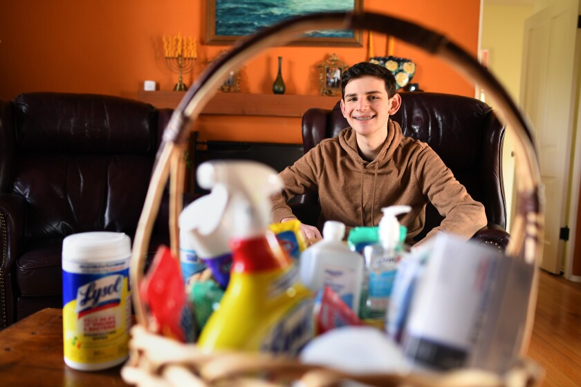Gabe Silk, 18, sits behind cleaning supplies he has sought out during the pandemic.