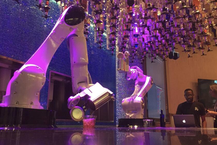 Robots sirven bebidas en el Tipsy Robot, que inauguró este verano dentro de las tiendas de Miracle Mile, junto al Planet Hollywood Casino en Las Vegas (David Montero / Los Angeles Times).