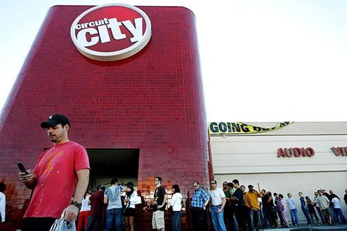 Shoppers wait in line to purchase discounted items at a Circuit City in Los Angeles. The bankrupt Virginia-based electronics retailer is shutting down its 567 U.S. stores and laying off 34,000 workers. More photos >>>
