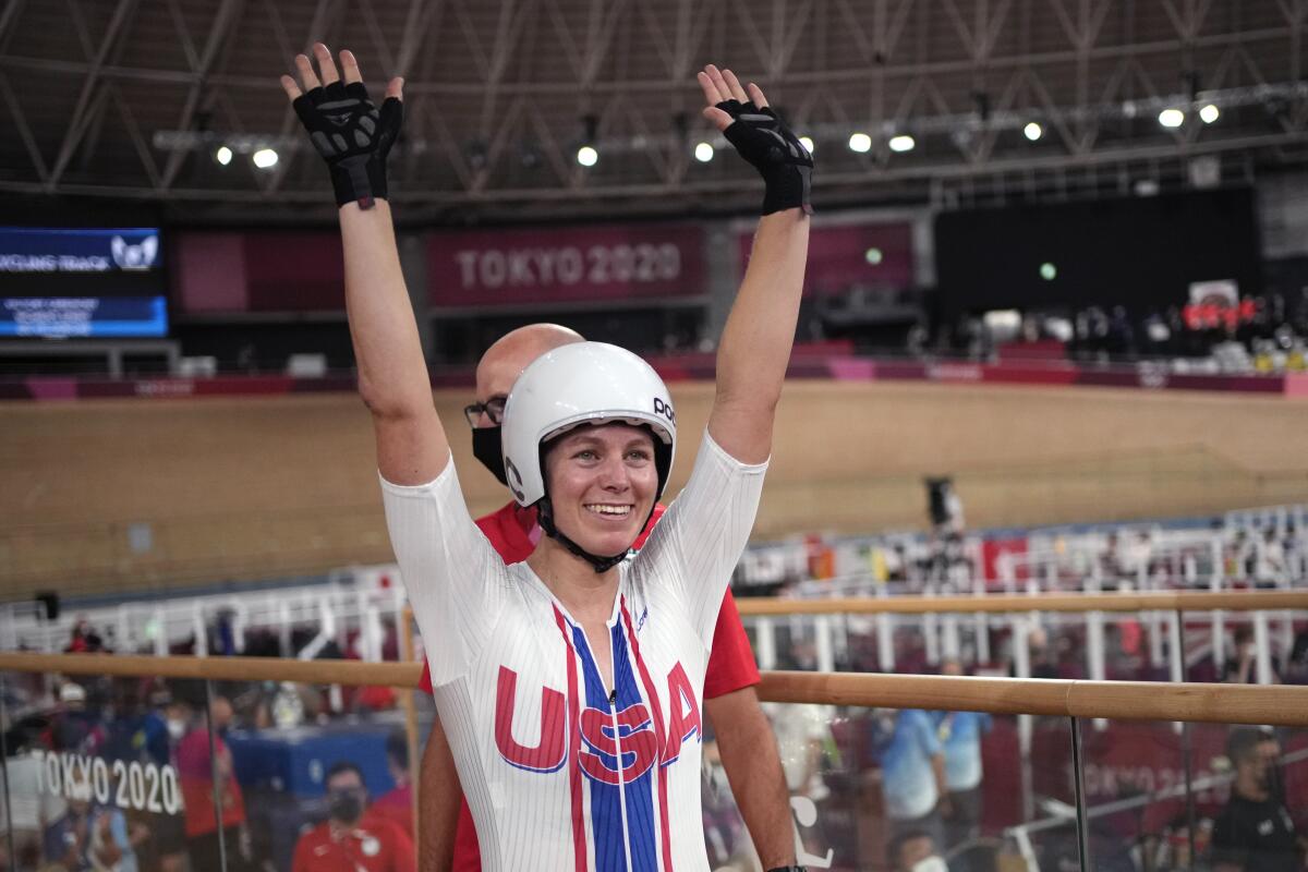U.S. cyclist Jennifer Valente holds up her hands and smiles after winning the women's omnium points race