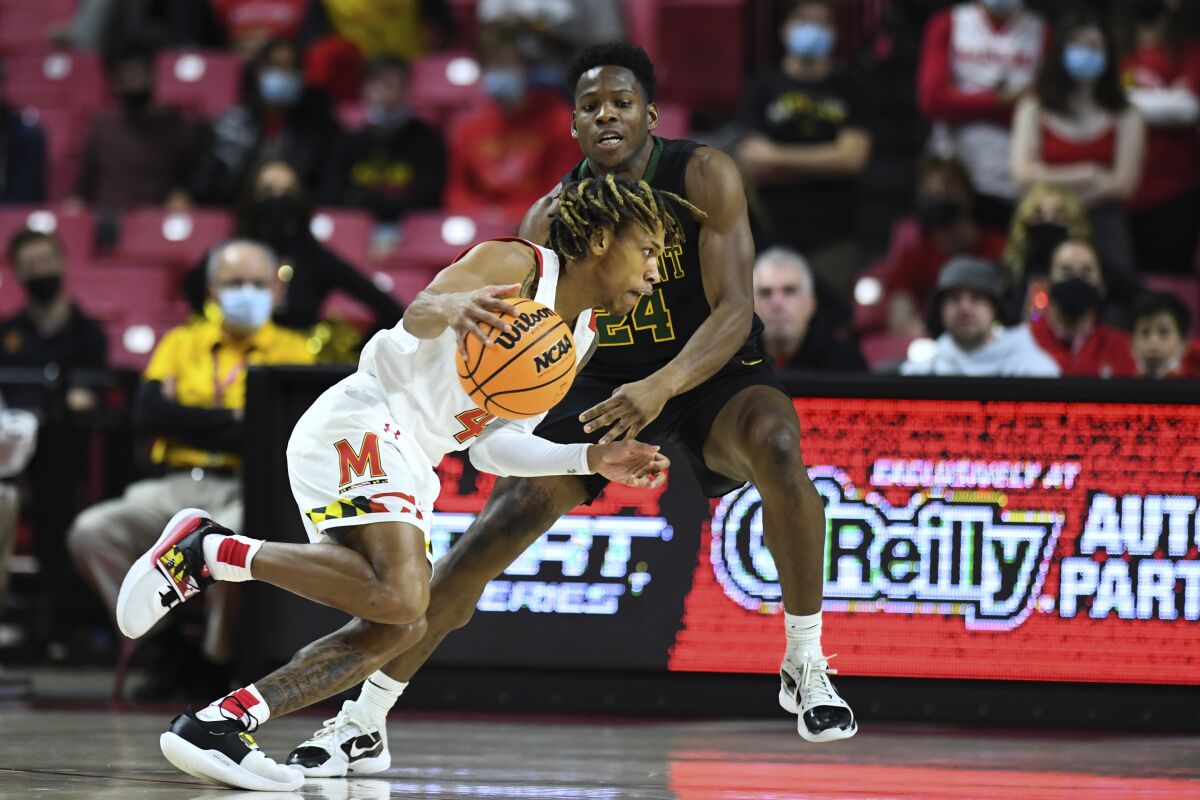 Maryland guard Fatts Russell (4) drives to the basket against Vermont guard Ben Shungu (24) during the first half of an NCAA college basketball game, Saturday, Nov. 13, 2021, in College Park, Md. (AP Photo/Terrance Williams)