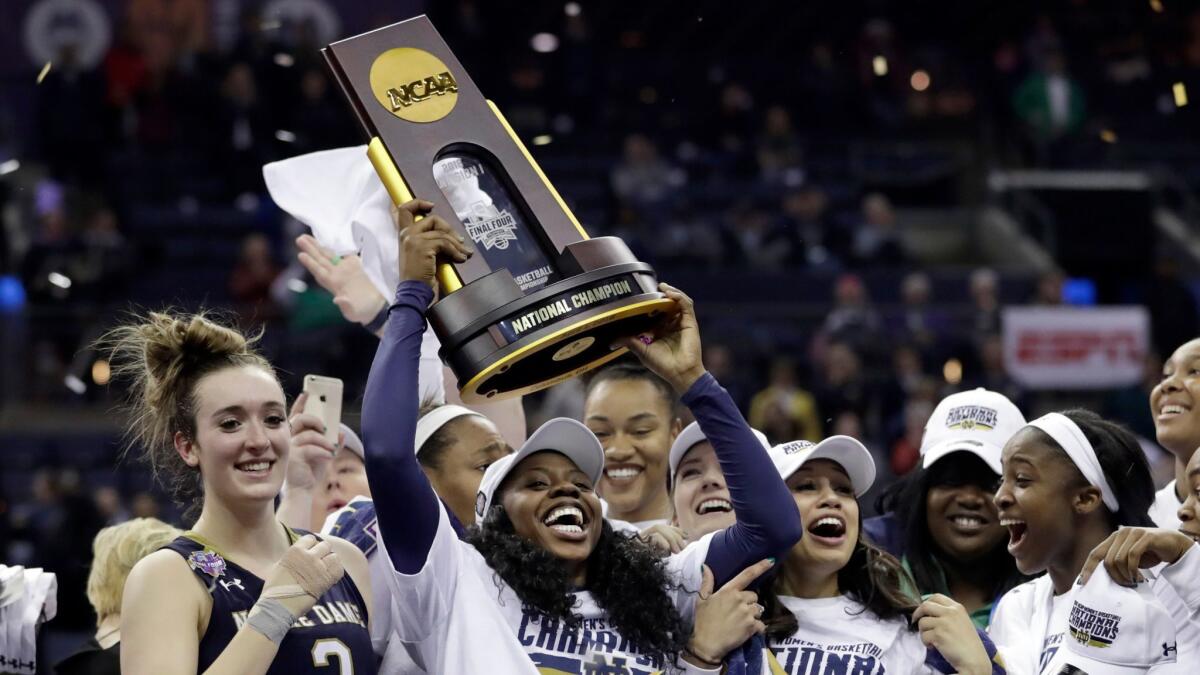 Notre Dame's Arike Ogunbowale holds the trophy after defeating Mississippi State in the final of the women's NCAA Final Four college basketball tournament.